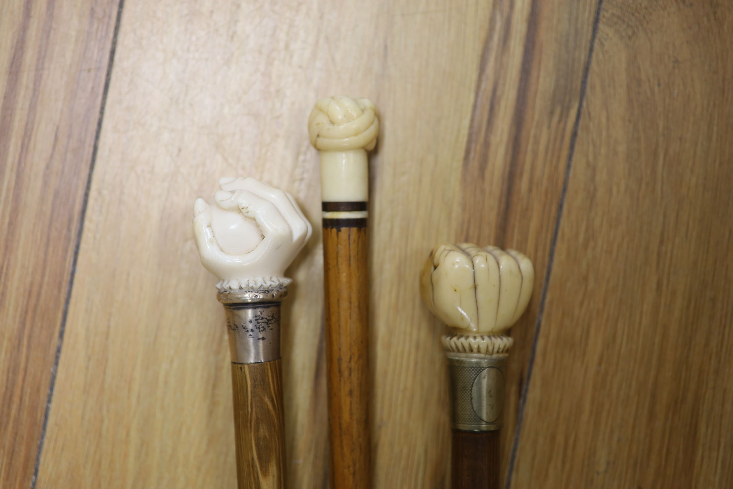 Two ivory mounted fist canes and a marine ivory knot baton, 19th century
